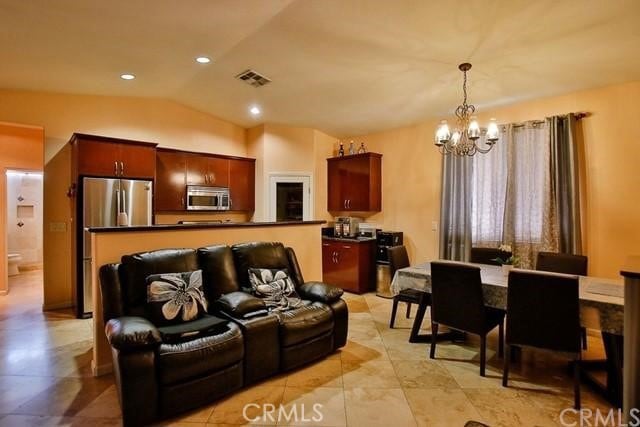 living room with an inviting chandelier and vaulted ceiling