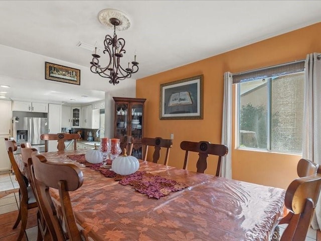 dining room with a chandelier, light tile patterned floors, and sink