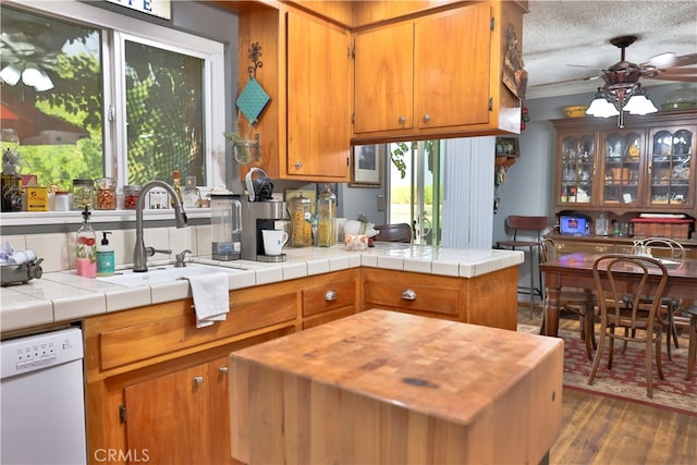 kitchen with tile counters, white dishwasher, dark hardwood / wood-style flooring, a textured ceiling, and ceiling fan