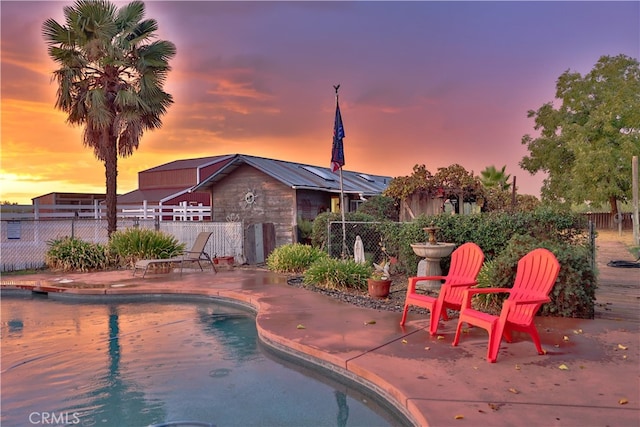 pool at dusk with a patio