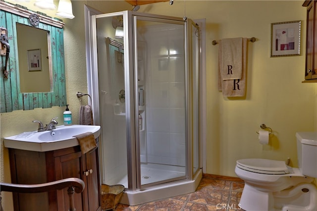 bathroom featuring toilet, vanity, tile patterned floors, and a shower with door