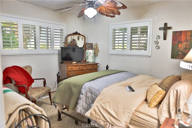 carpeted bedroom with ceiling fan and a textured ceiling