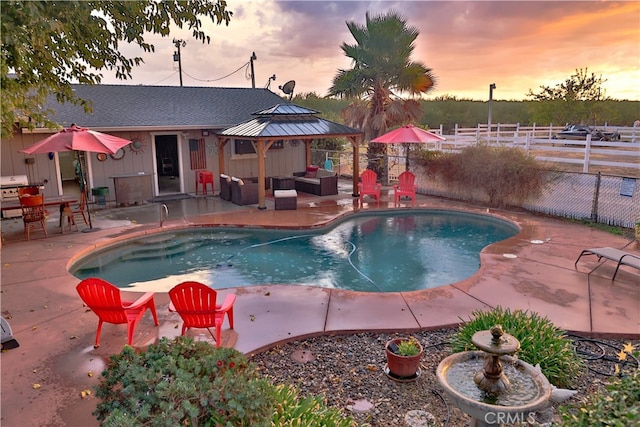 pool at dusk with a patio