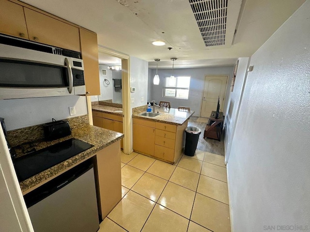 kitchen featuring hanging light fixtures, light tile patterned floors, sink, stainless steel appliances, and light brown cabinetry