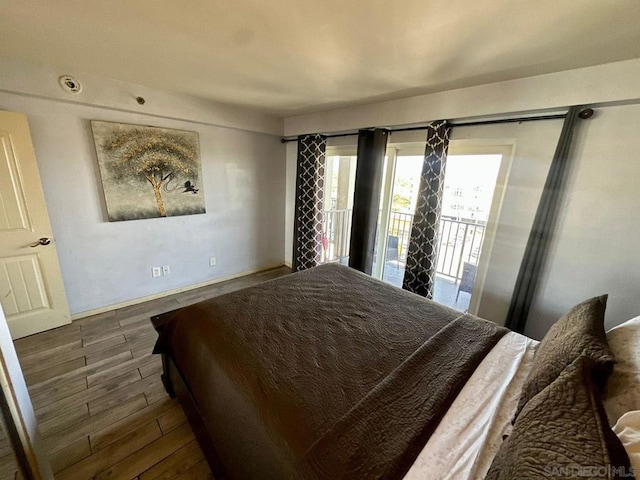 bedroom featuring access to exterior and dark hardwood / wood-style flooring