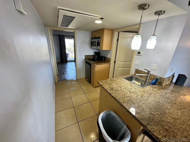 kitchen with stainless steel appliances, hanging light fixtures, light tile patterned floors, and sink