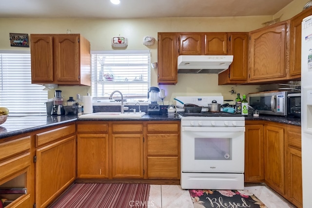 kitchen with white range, light tile patterned floors, and sink