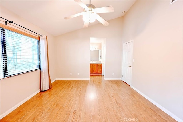 spare room featuring ceiling fan, lofted ceiling, and light wood-type flooring