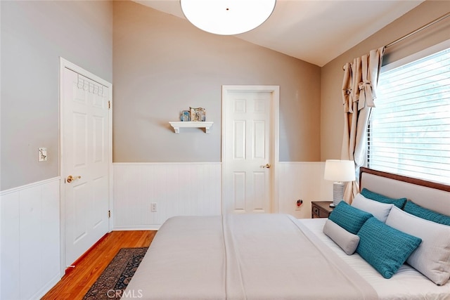 bedroom with vaulted ceiling and hardwood / wood-style floors