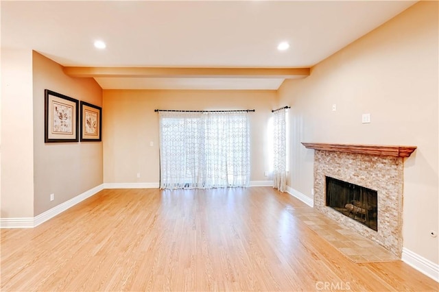 unfurnished living room with light hardwood / wood-style flooring and lofted ceiling with beams