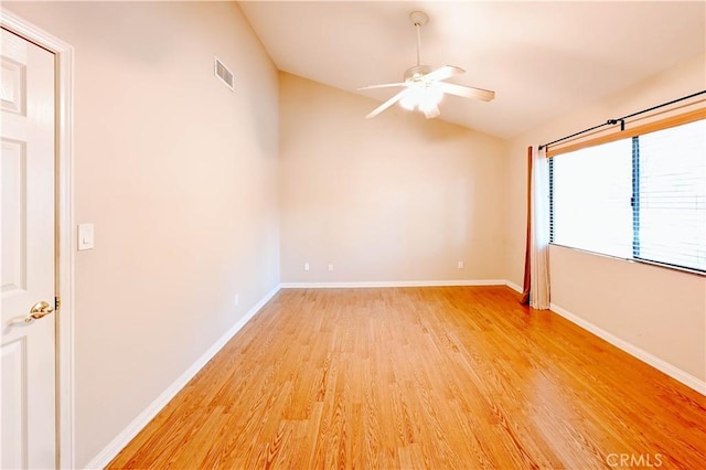 spare room with hardwood / wood-style floors, vaulted ceiling, and ceiling fan