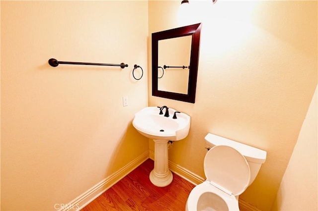 bathroom with hardwood / wood-style floors and toilet