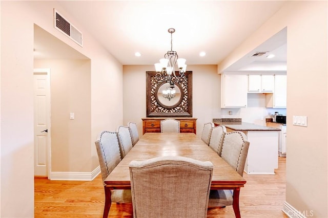 dining room with an inviting chandelier and light wood-type flooring