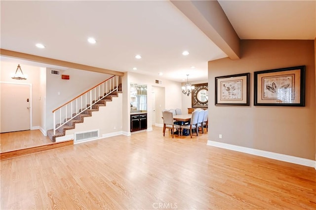 unfurnished living room featuring an inviting chandelier and hardwood / wood-style floors