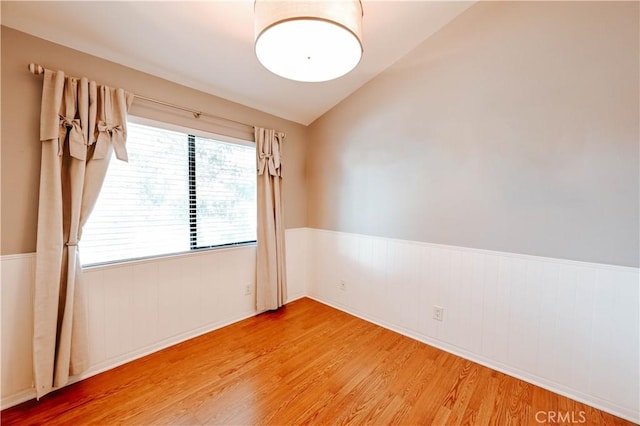 spare room with lofted ceiling and hardwood / wood-style floors