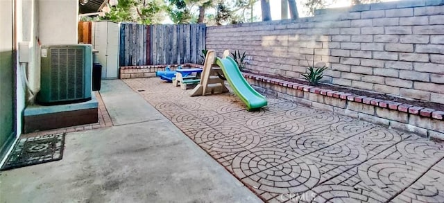 view of jungle gym with central AC and a patio