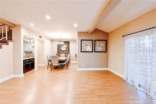 dining room with lofted ceiling with beams, light hardwood / wood-style floors, and a notable chandelier