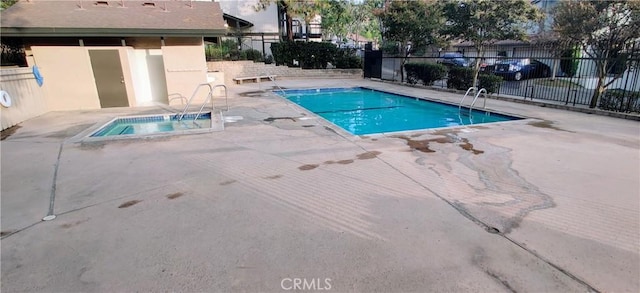 view of pool featuring a community hot tub and a patio