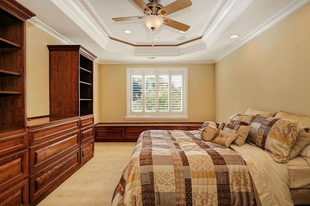 bedroom featuring a tray ceiling, ornamental molding, light colored carpet, and ceiling fan