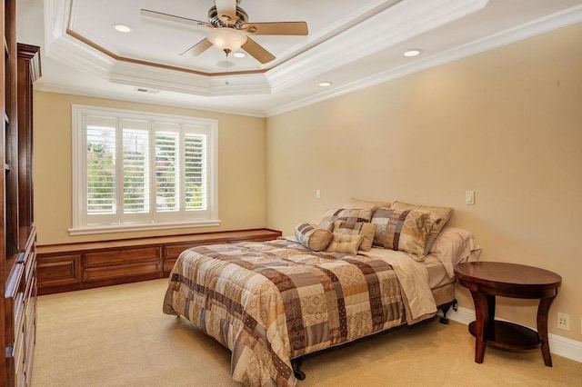 bedroom featuring ornamental molding, light carpet, ceiling fan, and a tray ceiling