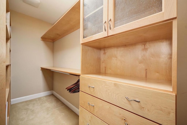 walk in closet featuring light carpet