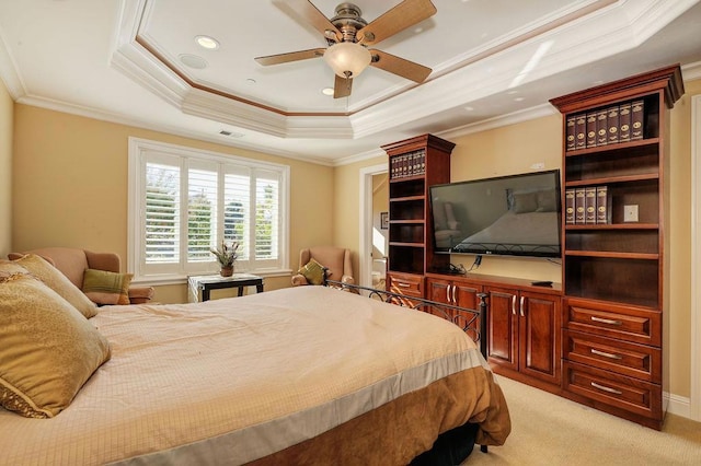 carpeted bedroom with ceiling fan, ornamental molding, and a tray ceiling