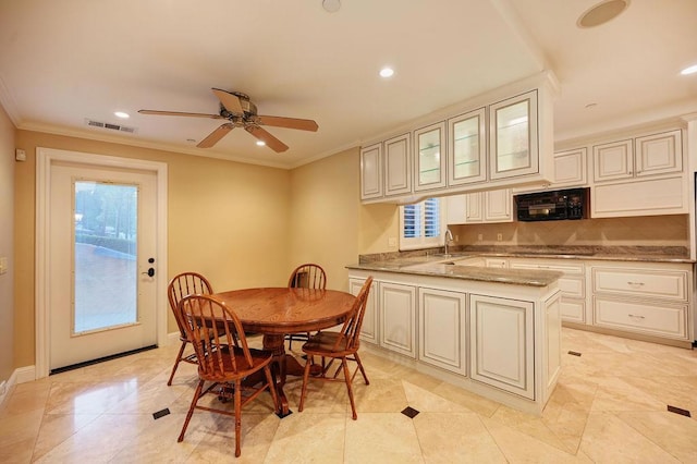 tiled dining space featuring crown molding, sink, and ceiling fan