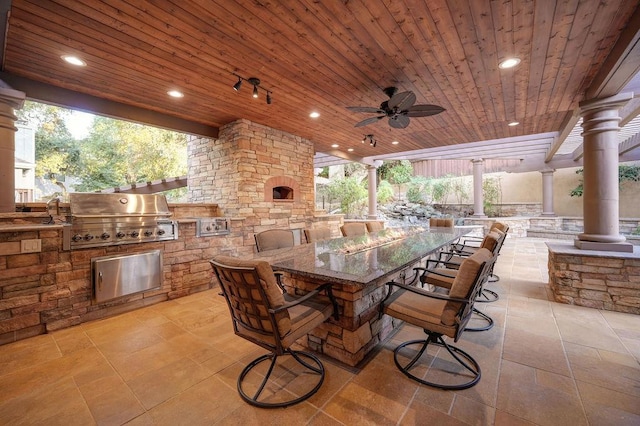 view of patio with an outdoor kitchen, a grill, ceiling fan, and a bar