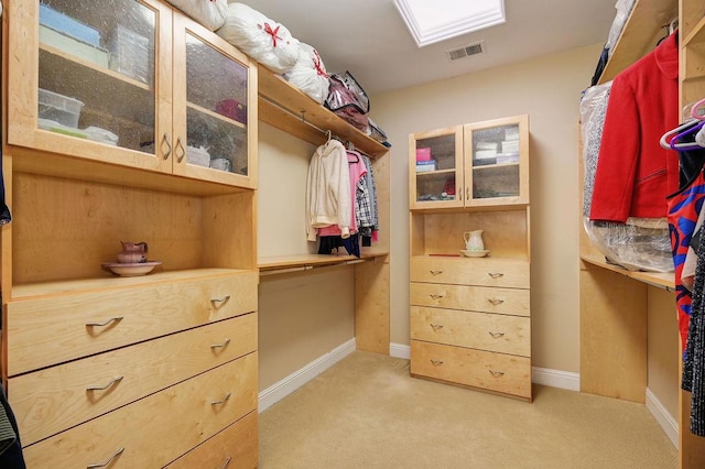 walk in closet featuring light carpet