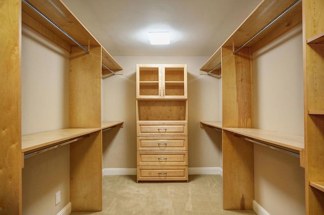 walk in closet featuring light colored carpet