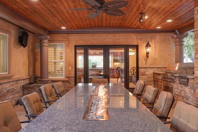 dining area featuring ornate columns, ceiling fan, french doors, and wooden ceiling