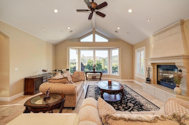 living room featuring a tiled fireplace, lofted ceiling, and ceiling fan