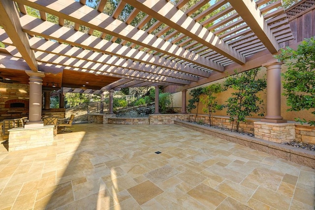 view of patio featuring exterior fireplace and a pergola