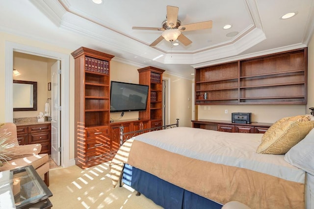 bedroom featuring connected bathroom, crown molding, light colored carpet, a raised ceiling, and ceiling fan