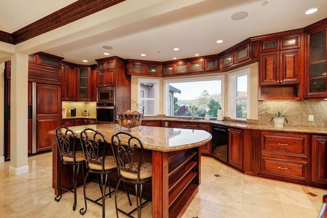 kitchen featuring a kitchen island, appliances with stainless steel finishes, sink, ornamental molding, and light stone counters