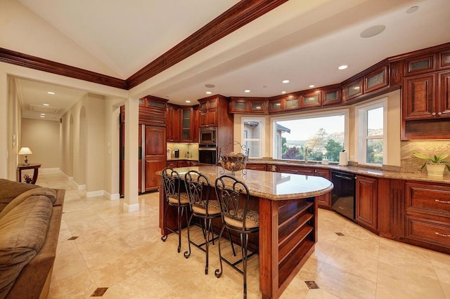 kitchen with vaulted ceiling, a kitchen island, appliances with stainless steel finishes, sink, and decorative backsplash