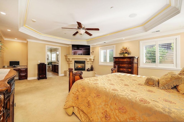 carpeted bedroom featuring multiple windows, a tray ceiling, and ceiling fan