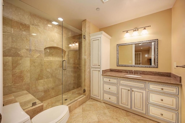 bathroom with vanity, tile patterned floors, a shower with door, and toilet