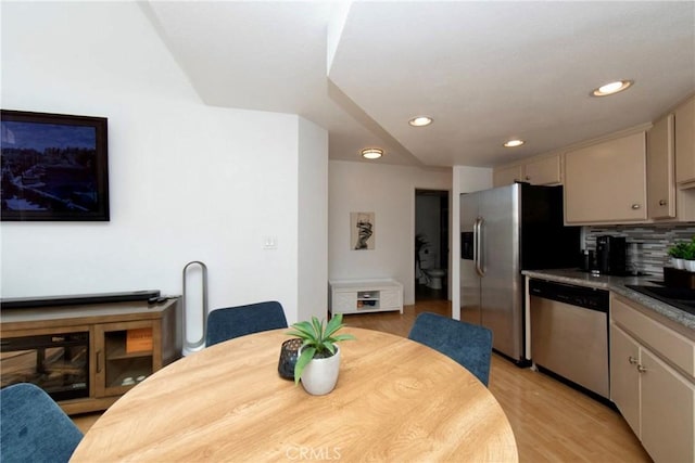 kitchen featuring backsplash, cream cabinets, stainless steel appliances, and light hardwood / wood-style flooring