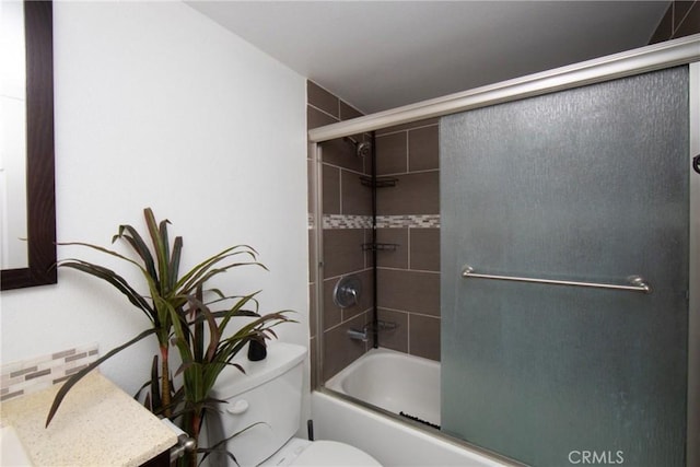 bathroom with toilet and shower / bath combination with glass door