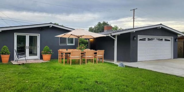 exterior space with a garage and a lawn