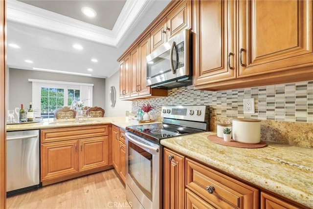 kitchen with sink, ornamental molding, stainless steel appliances, and light hardwood / wood-style flooring