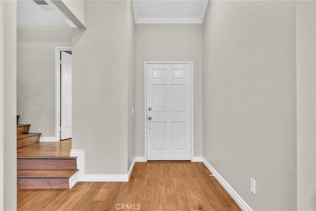 entrance foyer with light wood-type flooring and crown molding