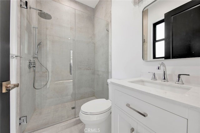 bathroom featuring vanity, toilet, and a shower with door