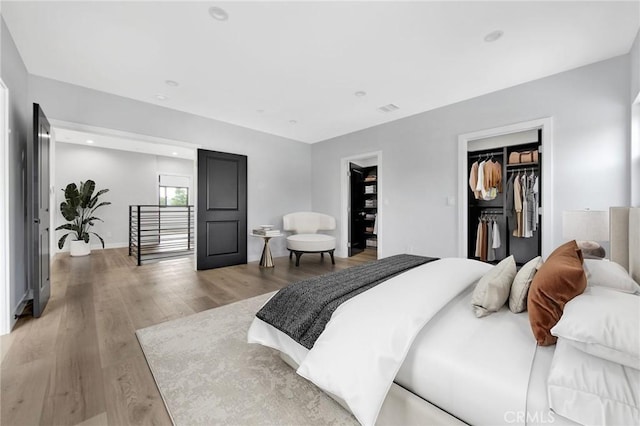 bedroom featuring light hardwood / wood-style flooring, a spacious closet, and a closet