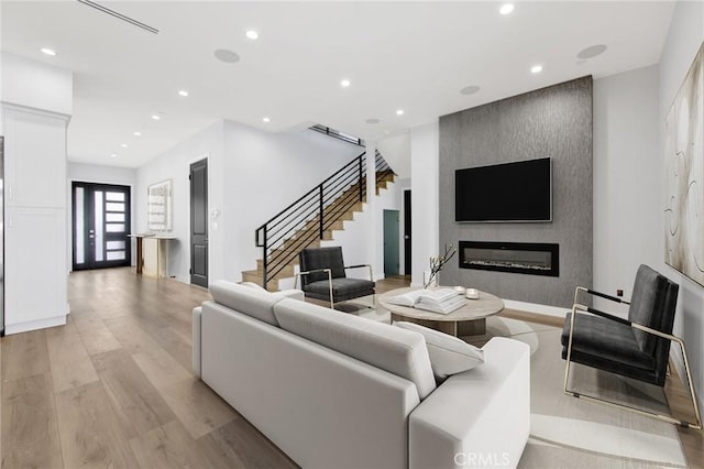 living room with a fireplace, french doors, and light hardwood / wood-style floors