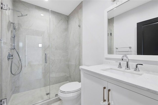 bathroom with vanity, toilet, and a shower with shower door