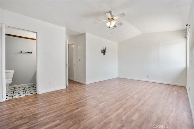 unfurnished bedroom featuring ceiling fan, lofted ceiling, ensuite bath, and light hardwood / wood-style floors