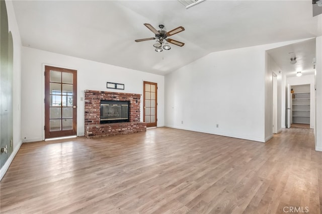 unfurnished living room with ceiling fan, light wood-type flooring, a fireplace, and vaulted ceiling