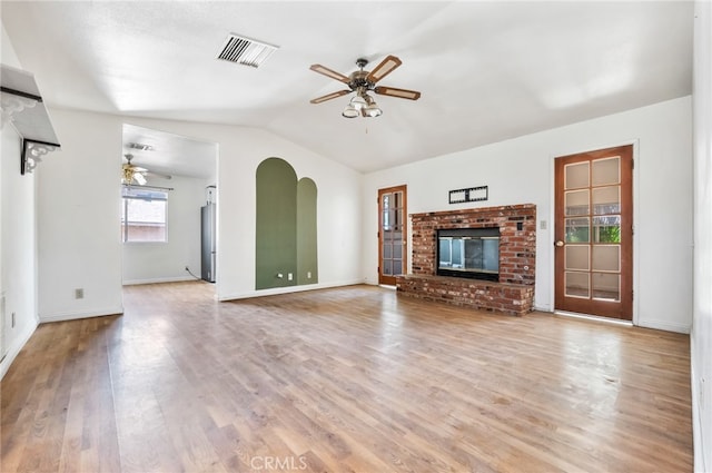 unfurnished living room with a fireplace, vaulted ceiling, ceiling fan, and light hardwood / wood-style flooring